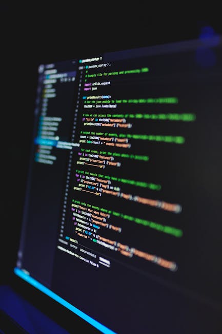 A close-up of a computer screen displaying lines of code in various colors on a dark background. The code includes syntax highlighting with green, orange, purple, and blue elements, indicating program
